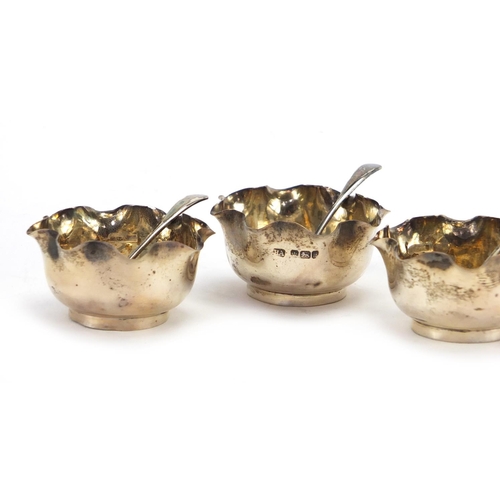 575 - Set of four circular silver open salts with spoons, by Atkin Brothers Sheffield 1902, housed in a fi... 