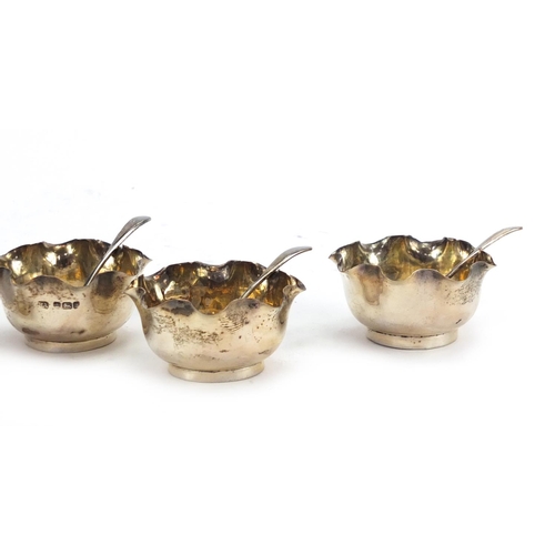 575 - Set of four circular silver open salts with spoons, by Atkin Brothers Sheffield 1902, housed in a fi... 