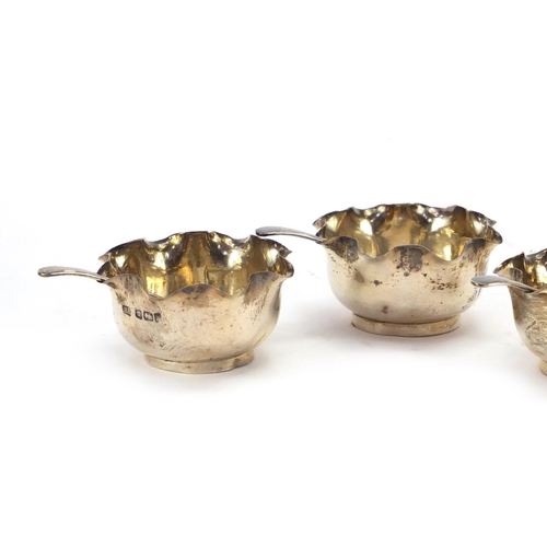 575 - Set of four circular silver open salts with spoons, by Atkin Brothers Sheffield 1902, housed in a fi... 