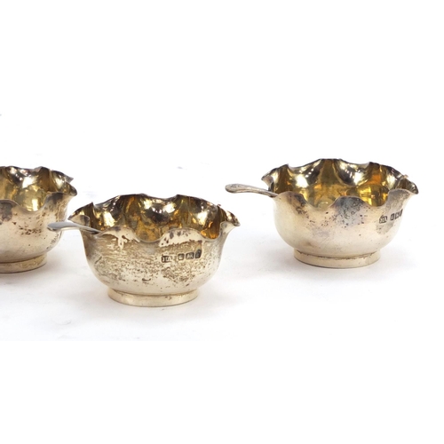 575 - Set of four circular silver open salts with spoons, by Atkin Brothers Sheffield 1902, housed in a fi... 