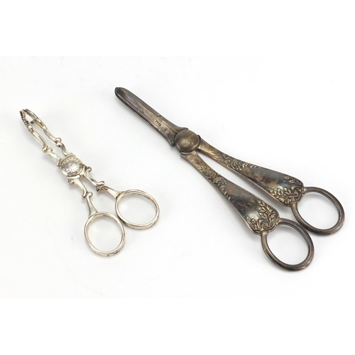 572 - Pair of Victorian silver grape scissors and a pair of silver sugar nips, London 1893 and 1914, the l... 