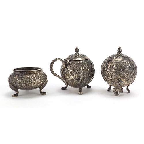 376 - Indian unmarked silver three piece cruet, embossed with flowers, the largest 5.5cm high, approximate... 