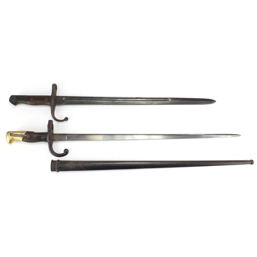 166 - Two military interest bayonets including a French example with scabbard, various impressed marks, th... 