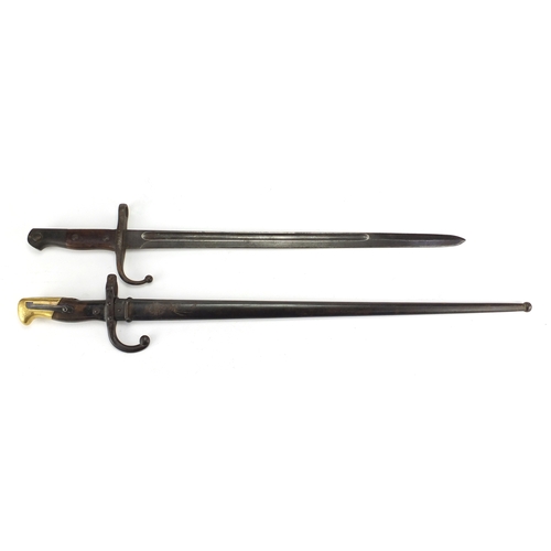 166 - Two military interest bayonets including a French example with scabbard, various impressed marks, th... 