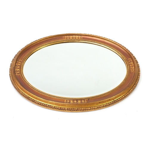 122 - Oval gilt painted wall hanging mirror with bevelled glass, 86cm x 66cm