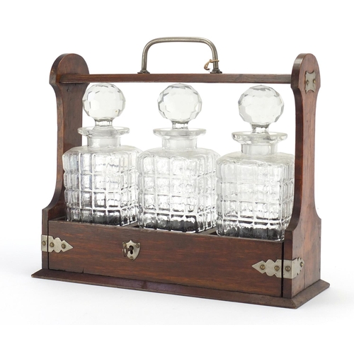 2241 - Oak three bottle tantalus with silver plated mounts, 31.5cm high