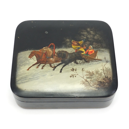 18A - Russian black lacquered box by Fedoskino, the hinged lid hand painted with figures in a sleigh, 6cm ... 