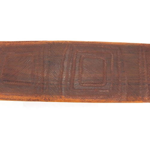 337 - Aboriginal parrying shield carved with tribal motifs, 77cm in length