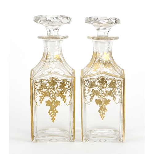432 - Pair of 19th century continental glass decanters, gilded with leaves and berries, each 20.5cm high