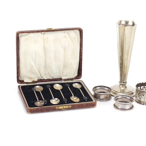 2542 - Silver items including a trumpet bud vase, napkin rings, set of six coffee bean spoons and two silve... 