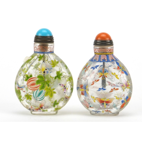 669 - Two Chinese glass snuff bottles with stoppers, each enamelled with butterflies, character marks to t... 