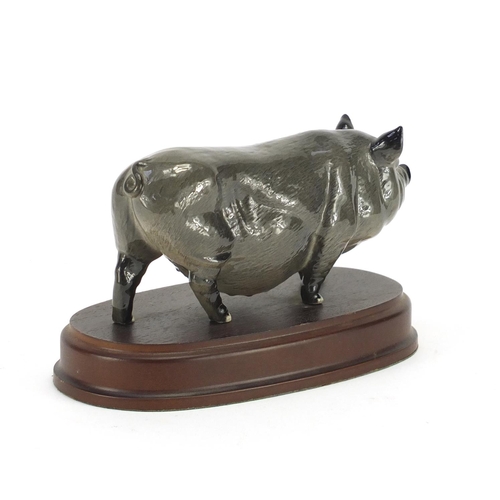 177 - Beswick pot belly pig on hardwood stand, the pig 15.5cm in length