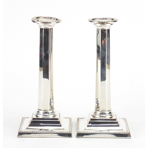 122 - Pair of silver plated column candlesticks, 21cm high
