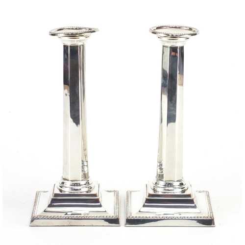 122 - Pair of silver plated column candlesticks, 21cm high