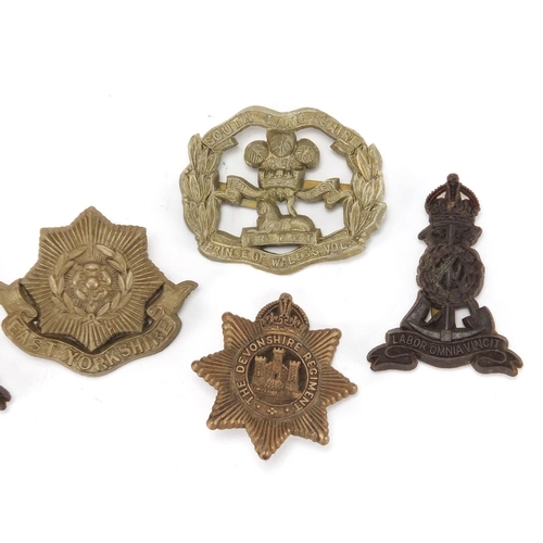 849 - Six Military interest cap badges including East Yorkshire and South Lancashire
