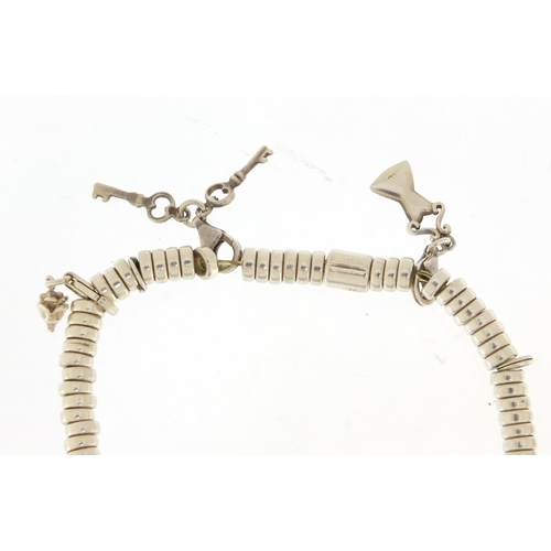 628 - Silver charm bracelet with charms and a white metal bangle, the charm bracelet 19.5g