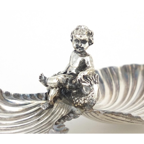 784 - Unmarked silver caviar dish, mounted with putti seated on a dolphin, 13.5cm wide, 67.0g