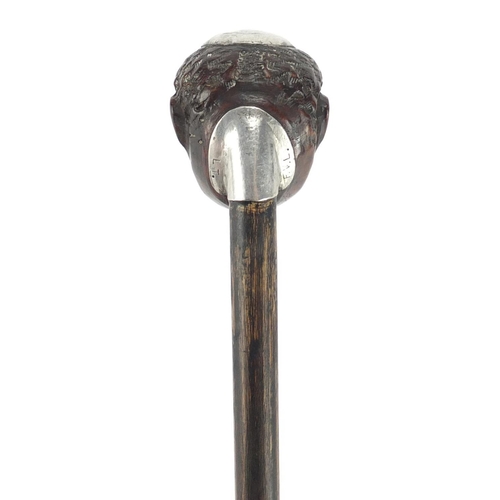 84 - Ebonised walking stick with carved head pommel and silver coloured metal mounts engraved FVL LT, 88.... 