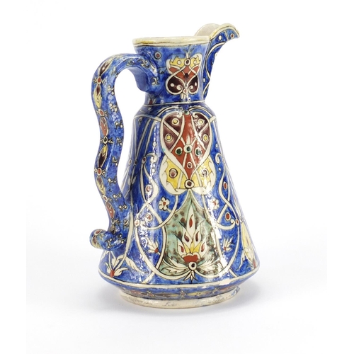 562 - Turkish Kutahya pottery jug hand painted with stylised flowers, 22cm high