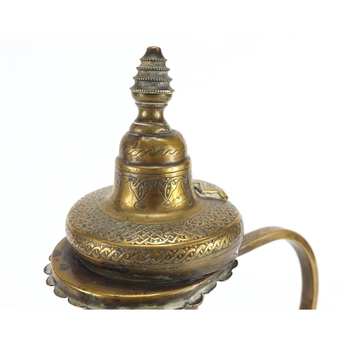 572 - Islamic brass water pot profusely engraved with calligraphy, 34cm high