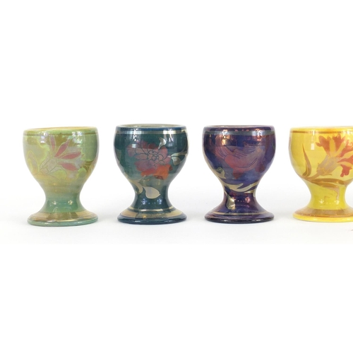 689A - Set of six Johnathon Chiswell Jones lustre egg cups, hand painted with stylised fish, flowers and in... 