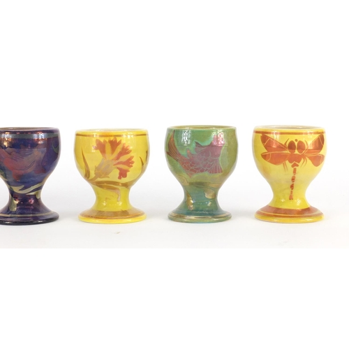 689A - Set of six Johnathon Chiswell Jones lustre egg cups, hand painted with stylised fish, flowers and in... 