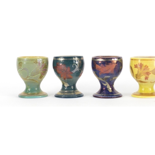 689A - Set of six Johnathon Chiswell Jones lustre egg cups, hand painted with stylised fish, flowers and in... 