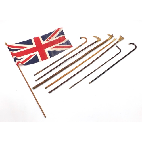 299 - Walking sticks, shepherds crooks and a Union Jack flag, three with silver mounts and four with horn ... 