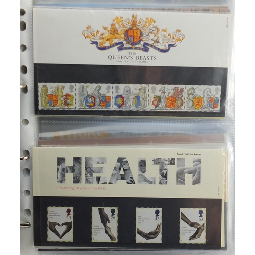 2554 - Royal Mint presentation packs arranged in an album, various denominations and genres