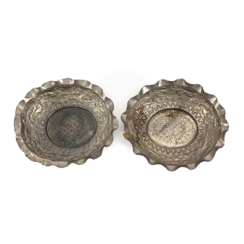 683 - Pair of Indian unmarked silver bowls, each embossed with lions chasing antelope, each 12cm wide, app... 