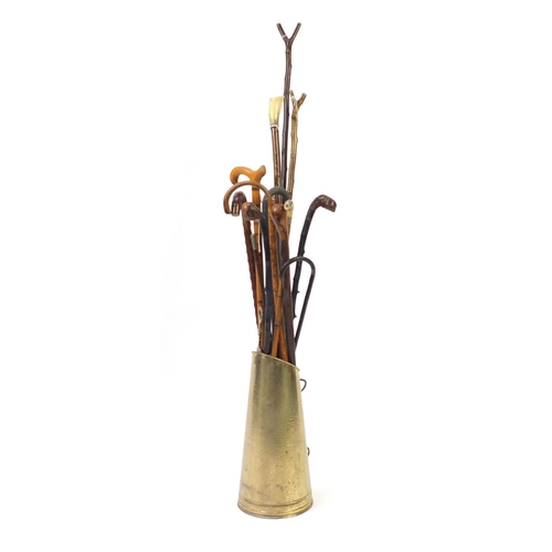 13 - Group of walking sticks and Military swagger sticks, some with horn handles, in a brass coal scuttle