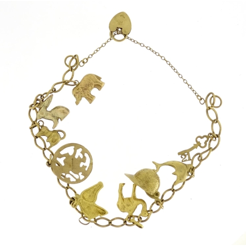 2713 - 9ct gold charm bracelet with mostly 9ct gold charms including jockey cap, camel, dolphin and horse, ... 