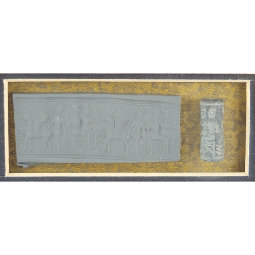 270 - Glazed display of an Assyrian cylinder seal, overall 36cm x 23cm