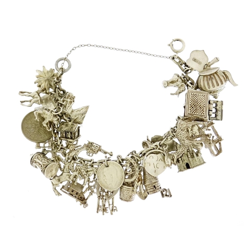 2678 - Heavy silver charm bracelet with a large selection of mostly silver charms, 105.0g