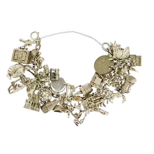 2678 - Heavy silver charm bracelet with a large selection of mostly silver charms, 105.0g