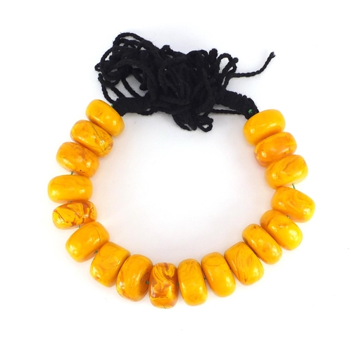 547 - Tribal interest pressed amber coloured bead necklace, each bead approximately 6cm in diameter, 1675.... 