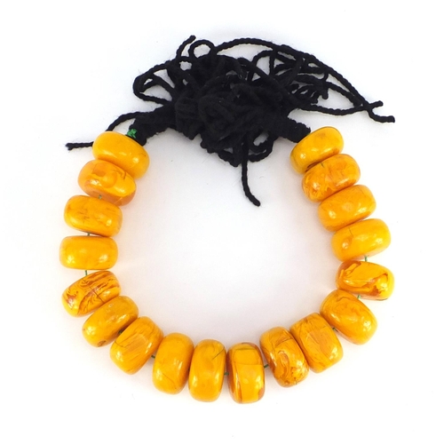 547 - Tribal interest pressed amber coloured bead necklace, each bead approximately 6cm in diameter, 1675.... 