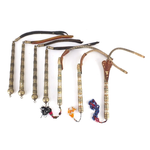 583 - Seven Afghan white metal and coppered Buzkashi whips