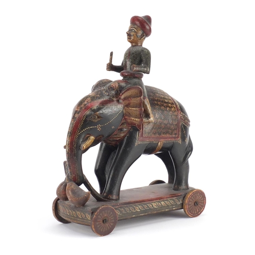 519 - Indian lacquered push along figure on elephant back, hand painted with flowers, 38cm high