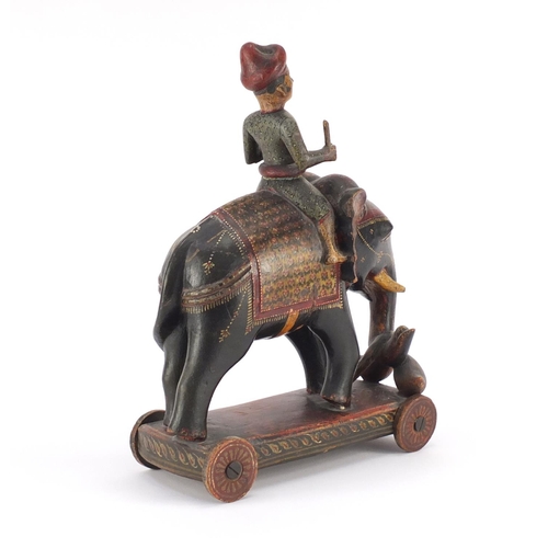 519 - Indian lacquered push along figure on elephant back, hand painted with flowers, 38cm high