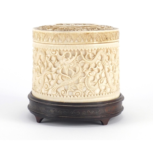 480 - Chinese Canton ivory pot and cover, finely carved with dragons amongst clouds, raised on a carved ha... 