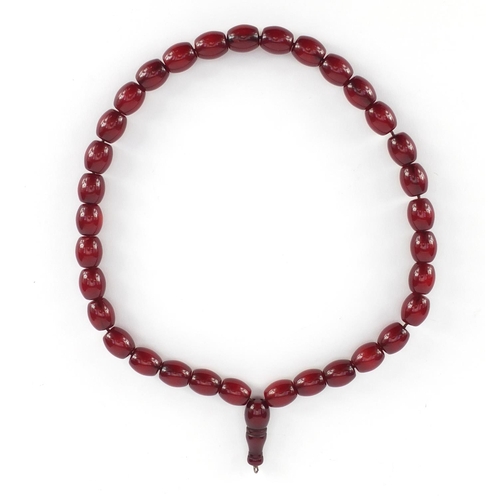 549 - Islamic cherry amber coloured bead prayer necklace, overall 49cm in length, the largest bead approxi... 