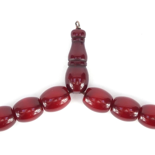 549 - Islamic cherry amber coloured bead prayer necklace, overall 49cm in length, the largest bead approxi... 