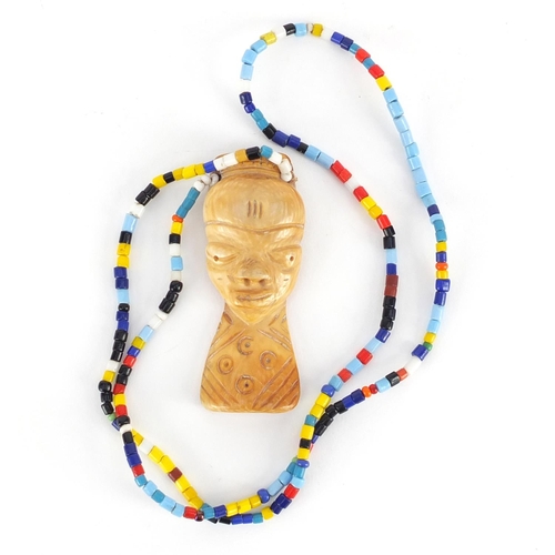 540 - African tribal interest carved ivory pendant on bead necklace, the pendant 7cm high