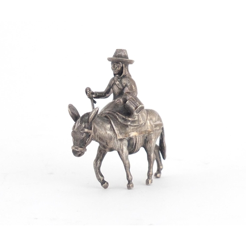 768 - Good quality unmarked silver model of a Dutch girl on a donkey, 5cm high, 57.6g