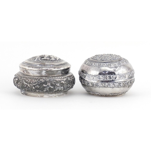 515 - Two Middle Eastern unmarked silver coloured metal circular boxes (both test as silver), embossed wit... 