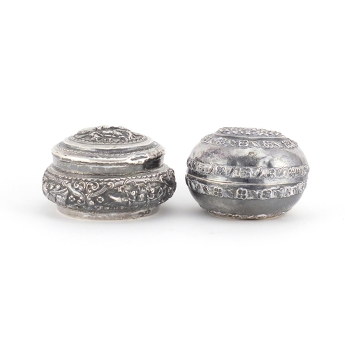 515 - Two Middle Eastern unmarked silver coloured metal circular boxes (both test as silver), embossed wit... 