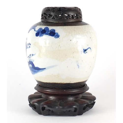 358 - Chinese blue and white ginger jar with carved hardwood lid on stand, the ginger jar hand painted wit... 