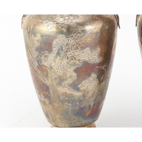 474 - Pair of Chinese silver vases with twin handles, each engraved with figures and cranes, character mar... 