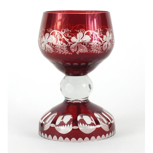 661 - Bohemian ruby glass table goblet, the bowl etched with vines and grapes on a faceted base, 22cm high